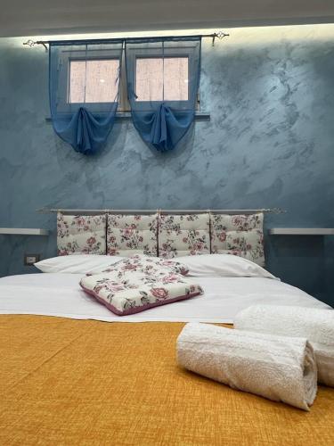 a bed in a bedroom with two windows at Garden green da VIRNA in Torre Annunziata