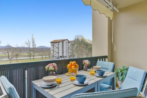 une table avec des oranges et des tasses sur un balcon dans l'établissement Charming flat with view on the Pyrénées - Saint-Jean-de-Luz - Welkeys, à Saint-Jean-de-Luz