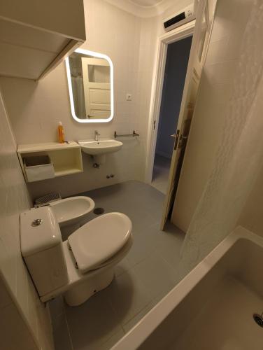 biała łazienka z toaletą i umywalką w obiekcie Casa Veríssimo w Porto