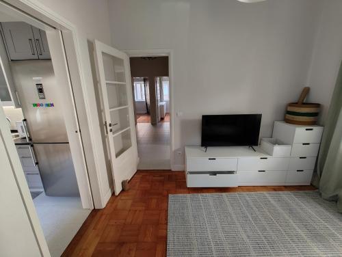 a white kitchen with a tv on a white dresser at Casa Veríssimo in Porto