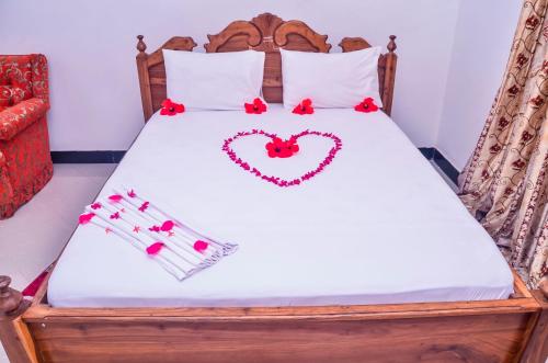 Una cama con un corazón dibujado en ella en Muhako Hotel en Dar es Salaam
