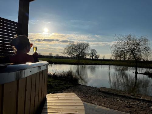 a child sitting in a hot tub looking at a lake at New Farm Cheshire Holidays in Winsford