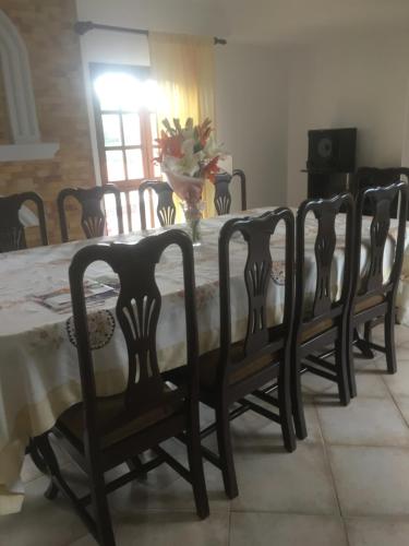 uma mesa de jantar com quatro cadeiras à volta em Como en tu casa em Tarija