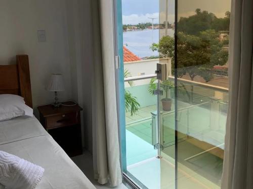 1 dormitorio con puerta de cristal que da a un balcón en Pousada Vilas Boas, en Barreirinhas