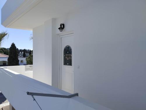 a white house with a white door on a white wall at Palma Apartment in Faliraki