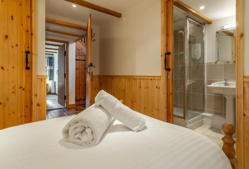 a bedroom with a bed with a shower and a sink at The Threshing Barn in Gwennap