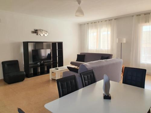 a living room with a table and chairs and a television at Toledo Horizon in Burguillos de Toledo