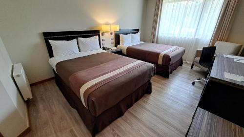 ein Hotelzimmer mit 2 Betten und einem Fenster in der Unterkunft Hotel Diego de Almagro Osorno in Osorno