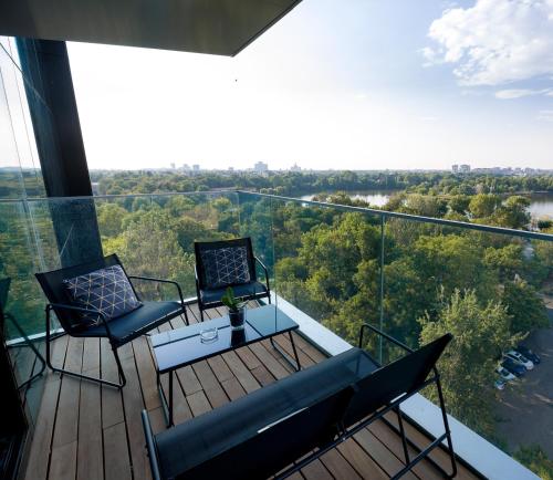a balcony with two chairs and a table and a view at ONE Tower Apartments in Bucharest