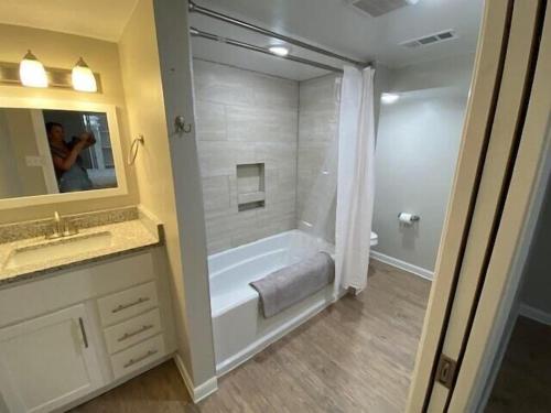 a bathroom with a tub and a sink and a mirror at Luxurious and peaceful in Topeka