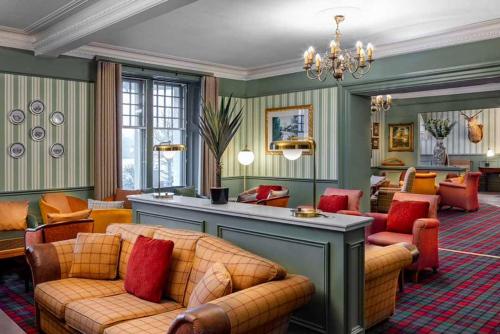 a living room with couches and a chandelier at Loch Rannoch Hotel and Estate in Kinloch Rannoch