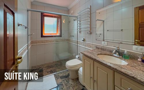 La salle de bains est pourvue d'un lavabo, de toilettes et d'une baignoire. dans l'établissement Recanto do Pepê, à Campos do Jordão