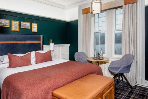 ein Schlafzimmer mit einem großen Bett und einer grünen Wand in der Unterkunft Loch Rannoch Hotel and Estate in Kinloch Rannoch