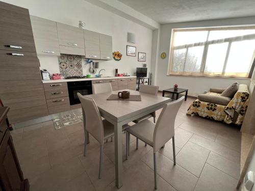 a kitchen and living room with a table and chairs at CASA ELIO IN VAL DI NOTO in Calabernardo