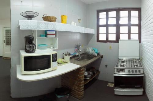 a kitchen with a microwave and a stove at Suíte de hóspedes independente com cozinha in Teresópolis