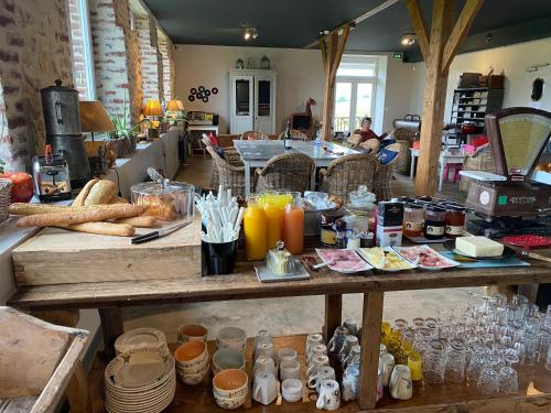 a large wooden table with food and drinks on it at Le Prieuré Chambres d'hôtes in Sainte-Preuve