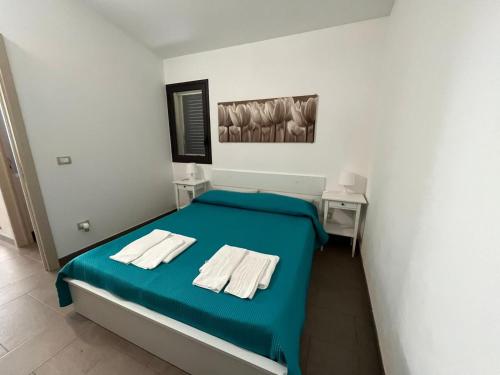 a bedroom with a blue bed with towels on it at CASA ELIO IN VAL DI NOTO in Calabernardo