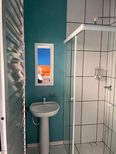 a bathroom with a sink and a glass shower at Chalé Canto da Viola in São Roque