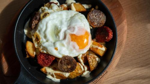 a bowl of breakfast food with an egg on top at Hotel Colonial in Colonia Sant Jordi