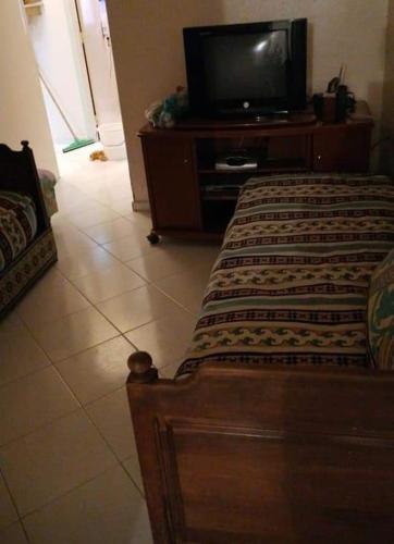 - une chambre avec un lit et une télévision sur une commode dans l'établissement Ain lbaida, à Casablanca