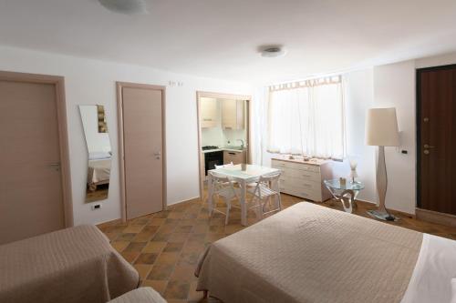 恩佩多克萊港的住宿－Guest House del Lido，一间卧室设有两张床、一张桌子和一个窗口