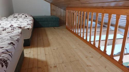 a bedroom with a bed and a wooden floor at Chalupa a apartmány Marika in Cerny Dul