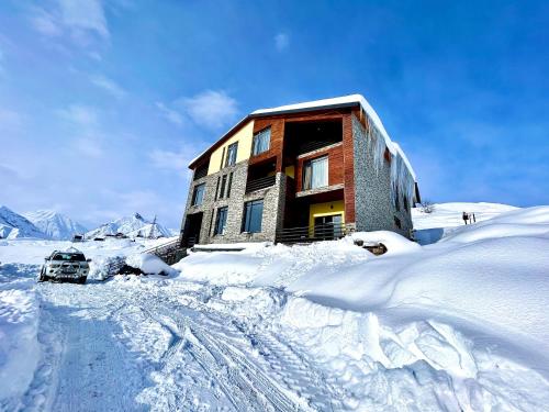 a building on a snow covered mountain in the snow at Dandelion Hotel Gudauri in Gudauri