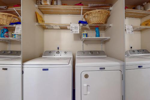 uma lavandaria com três máquinas de lavar roupa e prateleiras em Ventana Retreat em Tucson
