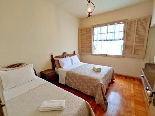 a hotel room with two beds and a window at Pousada Mundo Consciente in Piumhi