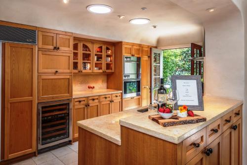 a kitchen with wooden cabinets and a counter with wine glasses at 3770 Stone's Throw home in Carmel