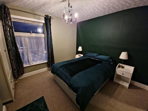 1 bedroom Sculcoates house Hull في هال: غرفة نوم خضراء بها سرير ونافذة