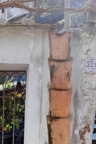 a building with a sign on the side of a window at #La limonaia della torretta in Minori