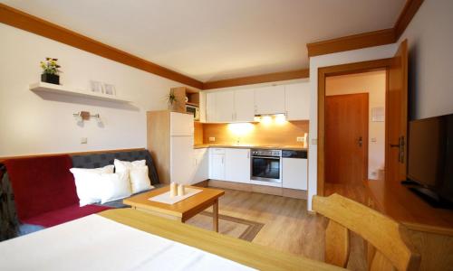 a small room with a bed and a kitchen at Appartementhaus Daniel in Saalbach Hinterglemm