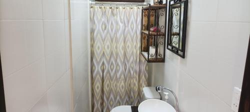 ein Bad mit einem WC und einem Duschvorhang in der Unterkunft Flor de Sacuanjoche, Chinandega in Chinandega