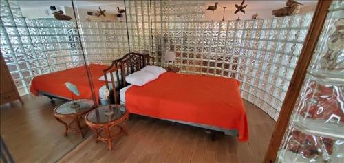1 dormitorio con cama roja, mesa y sillas en Saida IV Condos S4709, en South Padre Island