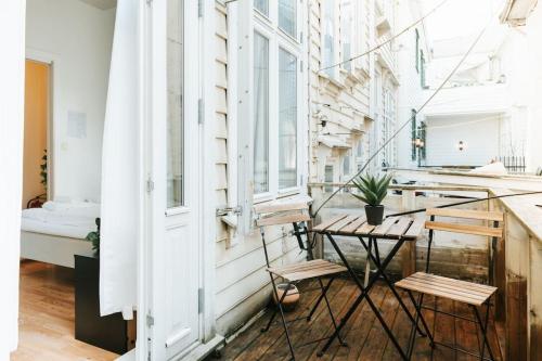 einen Balkon mit einem Tisch, Stühlen und einem Bett in der Unterkunft City Center Apartment in Bergen