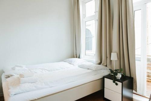 a white bed in a room with a window at City Center Apartment in Bergen