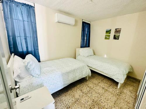 - une petite chambre avec 2 lits et une fenêtre dans l'établissement Ocean Breeze, à Punta Santiago