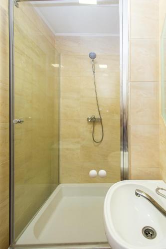 a shower with a glass door next to a sink at Центр. Острозького. Цум. 2 кімнати in Ternopilʼ