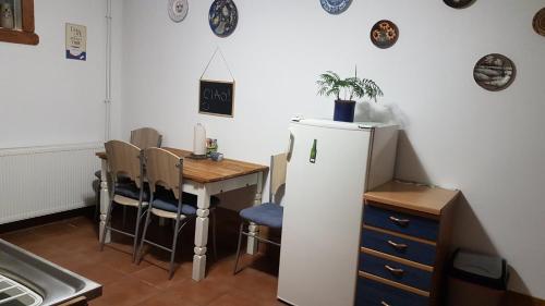 a kitchen with a table and a white refrigerator at Apartman Barbara in Daruvar