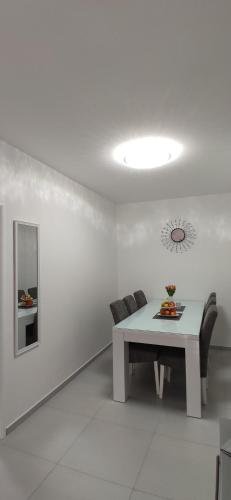 uma sala de estar branca com uma mesa e um sofá em Apartman Polaris Posušje em Posušje