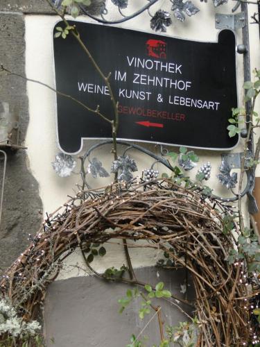 a sign on the side of a building with a wreath at Kleine Residenz am Zehnthof in Senheim