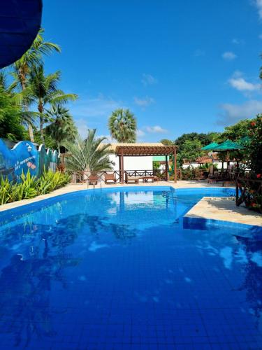 une grande piscine bleue avec un kiosque dans l'établissement Pousada e Restaurante Paraíso Natural, à Jericoacoara