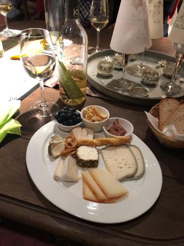 a table with two plates of cheese and wine glasses at Kleine Residenz am Zehnthof in Senheim