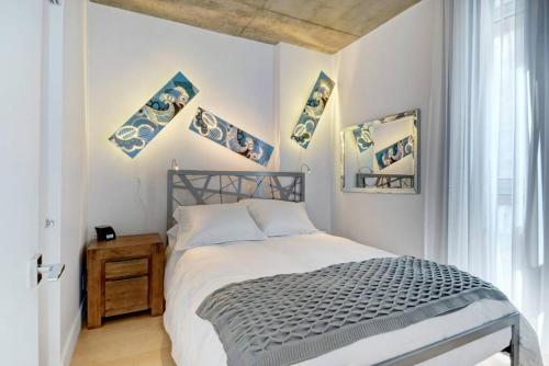 um quarto com uma cama e algumas fotografias na parede em Les Immeubles Charlevoix - 760-307 em Quebeque
