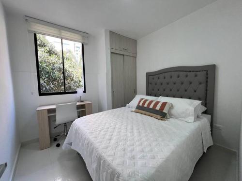1 dormitorio con cama, escritorio y ventana en Renewed 3hab/2bat in laureles, en Medellín