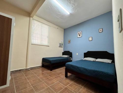 1 dormitorio con cama y reposapiés en Casa Perlita, acogedora y privada., en Palenque