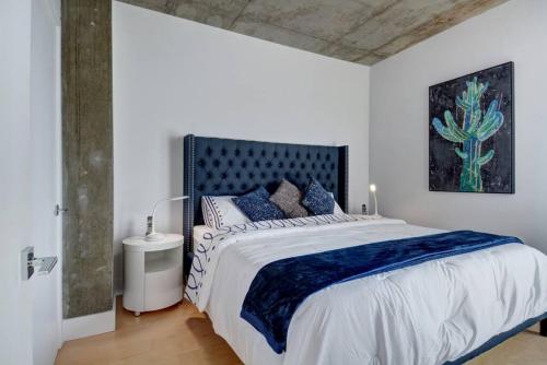 um quarto branco com uma cama grande e almofadas azuis em Les Immeubles Charlevoix - 760-505 em Quebeque