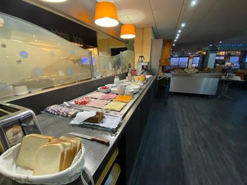 una línea de buffet en un restaurante con comida. en Hôtel De La Plage, en Calais