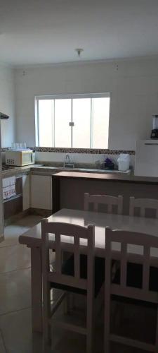 eine Küche mit einem Tisch und Stühlen in der Unterkunft Ap dos sonhos 2 in Poços de Caldas